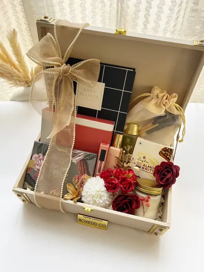 A luxurious birthday trunk hamper filled with a variety of curated items like a planner, cosmetics, a scented candle, and treats. This is perfect for celebrating a special milestone for a key team member.