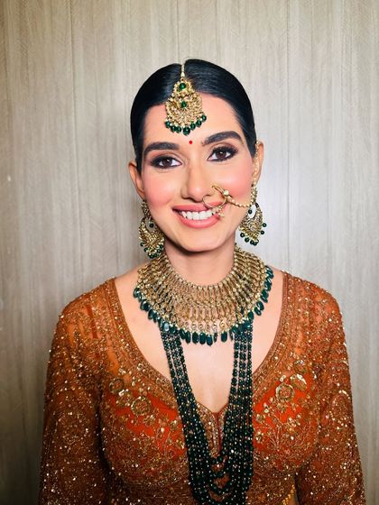 A bright, happy smile from a beautiful bride. Her makeup is classic and clean, with defined eyes and a rosy blush that brings out her joyful expression.