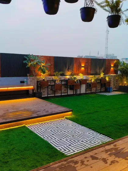 A wider view of the Uttam Nagar terrace, showing the wooden deck, bench seating, and planters integrated into the design.