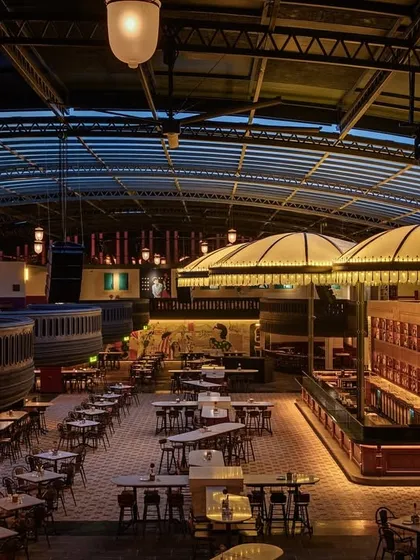 This is Jollygunj, a bar in Bangalore where I brought the spirit of old Calcutta to life. This expansive view showcases the multi-level layout and grand scale, centered around custom lighting fixtures that create a warm, inviting glow throughout the venue. The design focuses on creating different zones and moods within one cohesive space.