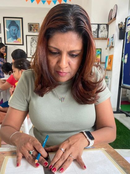 An instructor helps a student with her drawing, ensuring she understands the grid method for accurate proportions.