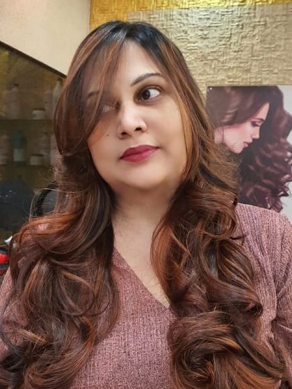 A happy client showing off her new look. The warm tones in her hair complement her complexion beautifully, and the soft layers frame her face perfectly.