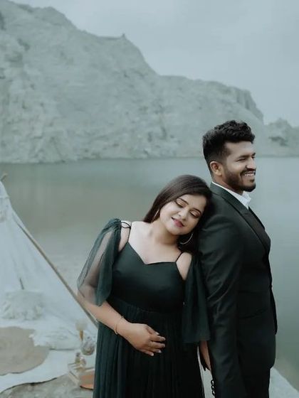 A peaceful and romantic pre-wedding portrait of a couple by the water, with a beautifully styled picnic setup.