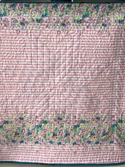 The back of the Glowing Star quilt, featuring a pink striped fabric.