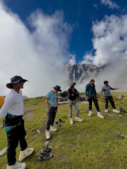 Our team getting ready for the day's climb on the Friendship Peak expedition, with the peak shrouded in clouds behind them.