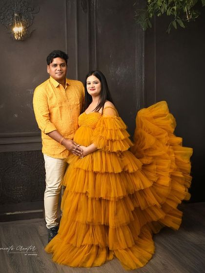 A bright and happy couple's portrait. The vibrant yellow gown and matching shirt create a cheerful and sunny vibe against a dark, textured backdrop.