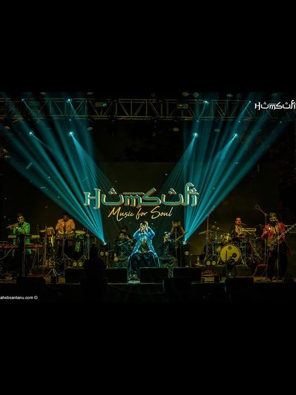 The full band under a stunning light display. This image captures the grandeur and scale of our live concert productions.