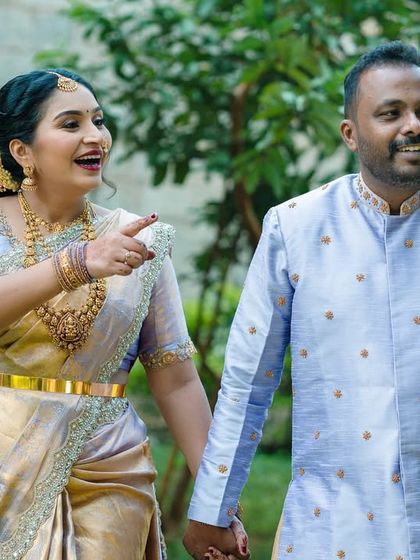 A candid, happy moment during a traditional maternity shoot. The beautiful silk saree and the couple's laughter make this a lively and joyful photograph.