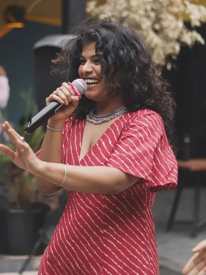 Look at that smile! This is the joy of grabbing the mic and singing your favorite song with a full live band backing you up. At our jams, every kalakar gets their moment.
