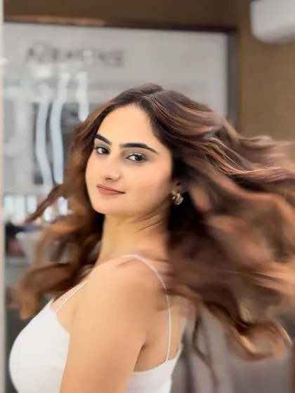 The movement in this shot really shows off the dynamic color of the caramel balayage. The hair looks full, healthy, and beautifully styled.