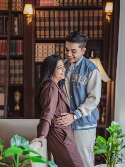 A sweet and casual indoor moment. The couple shares a happy, candid interaction in a cozy library setting, showcasing their relaxed and comfortable connection.