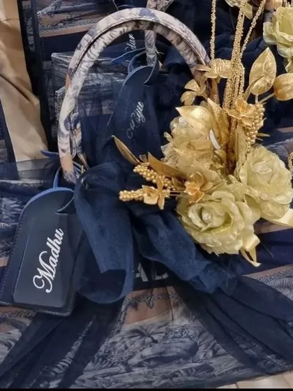 The anniversary gift set, beautifully wrapped with a navy blue tulle and golden flowers, ready to be presented.