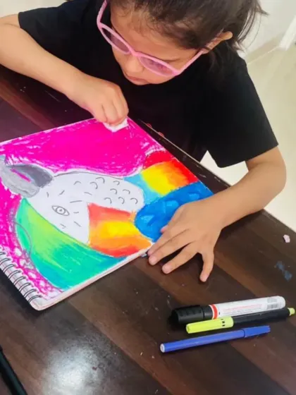 This student is carefully adding the final touches to her colorful macaw painting. I encourage my kiddos to be bold with their color choices, and this vibrant pink background makes the entire piece so joyful.
