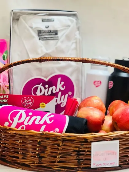 I work with brands to create hampers that reflect their identity. This wicker basket for 'Pink Lady' is filled with on-brand merchandise, apparel, and fresh apples, creating a unique and impactful corporate gift.