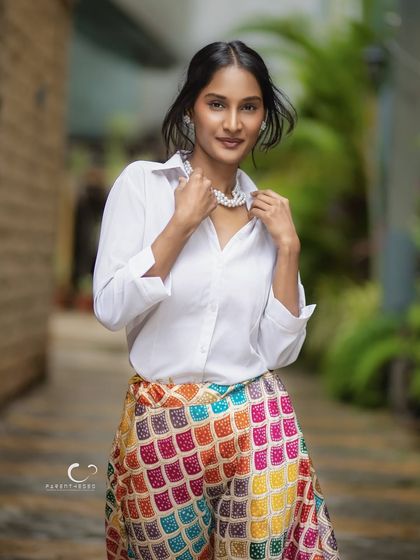 A warm and inviting smile that lights up the frame. This outdoor portrait feels candid and personal, capturing a moment of genuine connection and happiness.