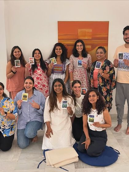 A happy group from a workshop, each holding a card that resonated with them. These gatherings are about more than just yoga; they are about self-reflection and shared discovery.