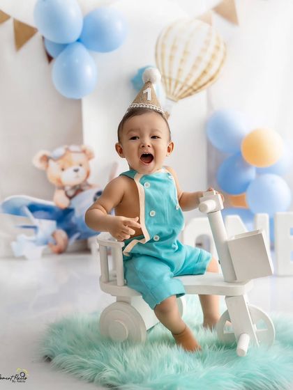 Sometimes the biggest smiles come with the biggest yawns. This candid moment from a first birthday shoot captures the real, unscripted personality of a one-year-old.