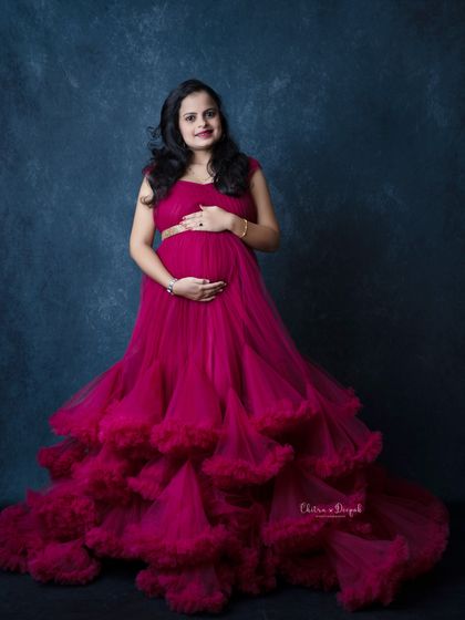 A full view of this magnificent magenta gown. The layers of ruffles create incredible texture and volume for a high-fashion maternity look.