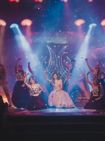 The bride and her backup dancers in a powerful pose, with the stage lighting and cosmic backdrop creating a stunning visual.