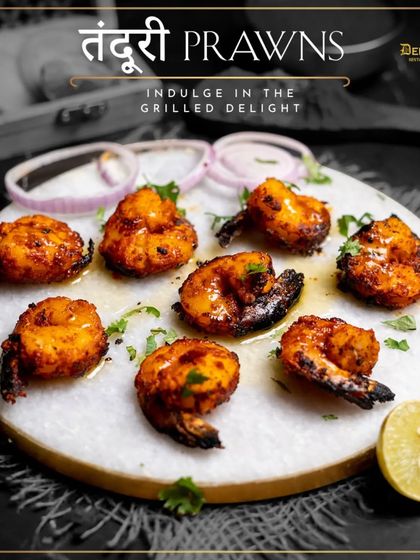 Indulge in the grilled delight of our Tandoori Prawns. This image captures the beautiful char and vibrant color of the prawns, served on a marble platter.