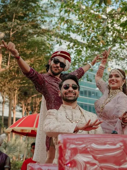 The groom enjoying his grand Baraat procession from a decorated vehicle, surrounded by his closest friends and family.