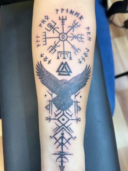 A Viking-inspired tattoo featuring a Vegvisir (Norse compass), a raven, and other powerful runes. This design is for those who connect with the warrior spirit and mythology of the Norse people.