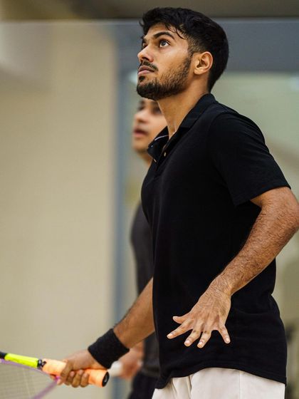 Rahil Peris intently watches the ball after his shot. This image captures the strategic side of squash, where players are always thinking two or three shots ahead.