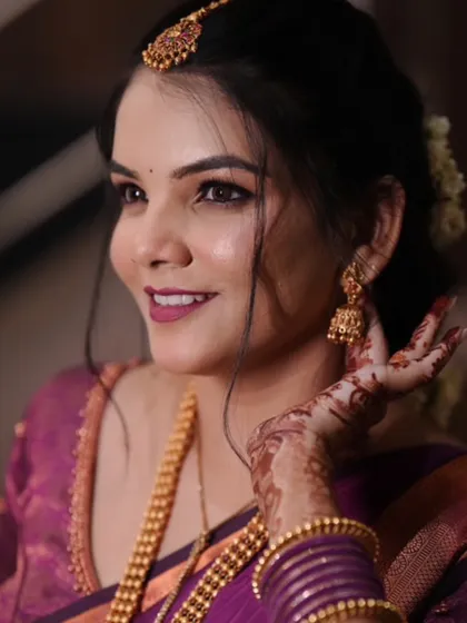 A close-up portrait highlighting the bride's flawless makeup and traditional gold jhumkas.