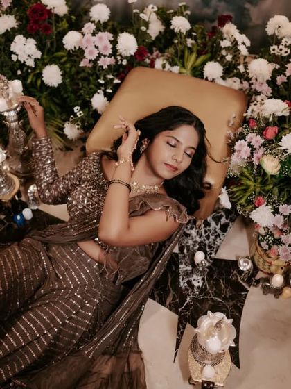 A dramatic overhead shot of the bride lying amidst a sea of flowers during her Mehendi.