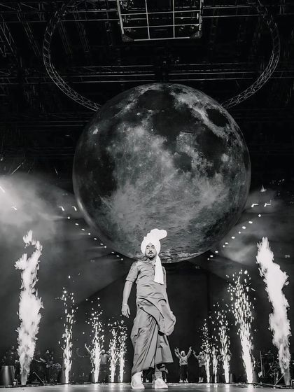 The moon on stage with Diljit Dosanjh. A creative and iconic black and white shot from his live concert, capturing the grand scale and artistic vision of the performance.