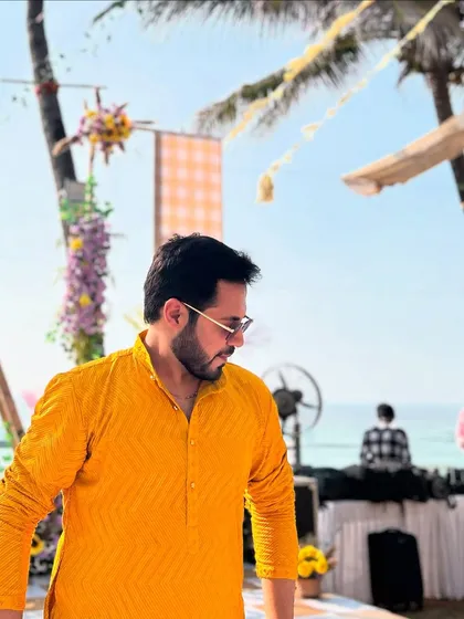 A candid shot at a beachside Haldi event. The beautiful setting and the yellow kurta perfectly match the festive vibe.