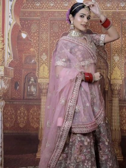 A model wearing a beautiful floral printed lehenga in a mauve-pink shade. This is a light and elegant option for a day wedding or a bridesmaid.