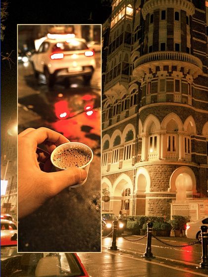 A cup of cutting chai in hand, with the magnificent Taj Mahal Palace Hotel lit up in the background on a rainy night.