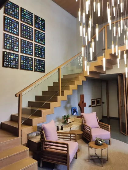 The full view of the twelve-panel installation, showing how it complements the modern wooden staircase and dramatic lighting.