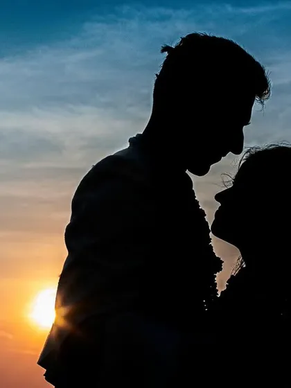 A stunning sunset silhouette of a couple. The deep colors of the sky create a breathtaking backdrop for this intimate and romantic portrait.