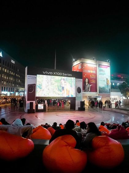 The energy of a packed screening at the DLF CyberHub amphitheatre. The combination of a huge screen, city lights, and a captivated audience makes for an electric atmosphere.