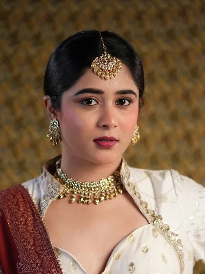 A close-up of a modern-traditional look I created for a photoshoot. I focused on a flawless matte base, a defined berry lip, and clean eye makeup to complement the intricate gold jewelry and elegant outfit.