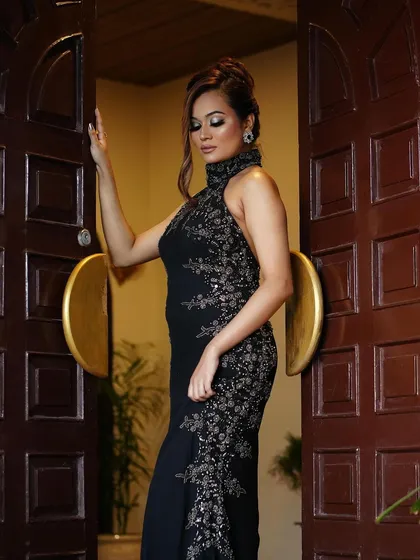 A full shot of this glamorous look. The client is wearing a stunning black gown, and the smoky eye makeup adds to the overall fierce and fabulous vibe.