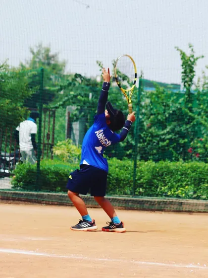 A young player from our academy practicing his serve with great form and extension.