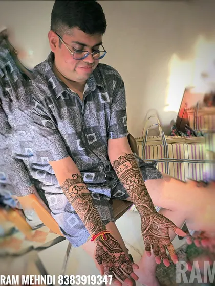 A final shot of the groom proudly displaying his full-arm mehndi. The design is a mix of traditional Indian motifs and personalized elements that reflect his style.