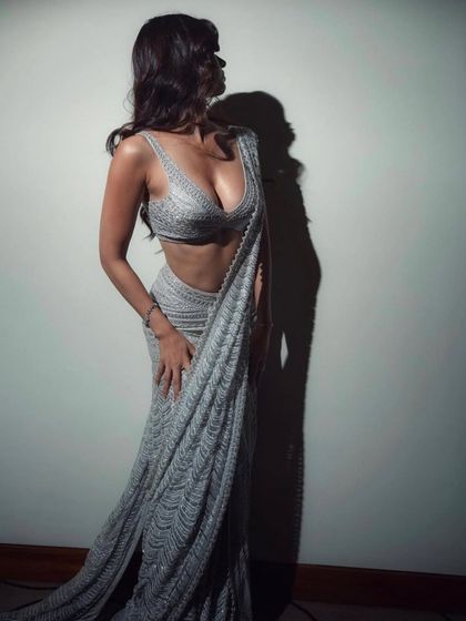 Disha Patani styled in a shimmering, pre-draped saree by Ritika Mirchandani. This look is a masterclass in modern ethnic wear, combining the elegance of a saree with the ease of a gown.