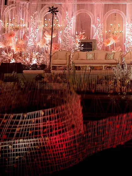 A creative shot showing the reflection of the ceiling installation on a mirrored surface, with the beautifully lit stage in the background. This highlights the interplay of light and reflection in the design.