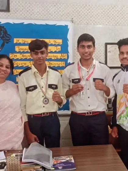 A school principal with our medal-winning boxers. This shows the strong partnership we have with educational institutions.