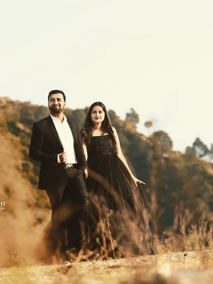 A pre-wedding portrait taken in the hills of Tehri. The warm, rustic tones of the landscape create a beautiful contrast with the couple's formal black attire.