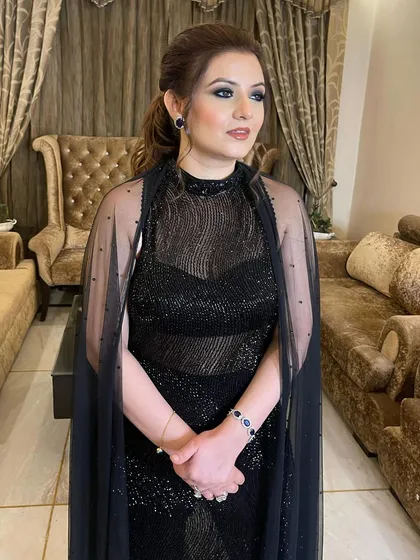 A classic black smokey eye for this beauty. It's a timelessly chic look that pairs perfectly with her elegant black caped outfit.