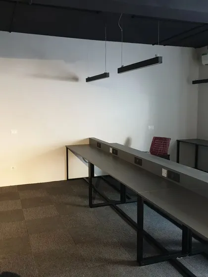 Another view of the Amigo co-working office project. The custom-built long desks feature integrated power outlets for a clean, wire-free setup.
