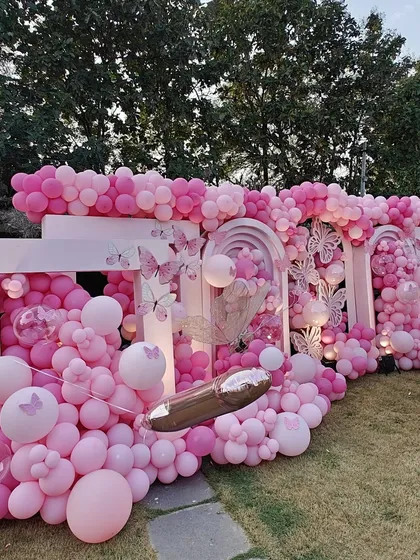 Another view of the magnificent pink butterfly wall. This angle highlights the intricate details, including the different sizes of butterflies and the seamless blend of various pink balloons to create texture and depth.
