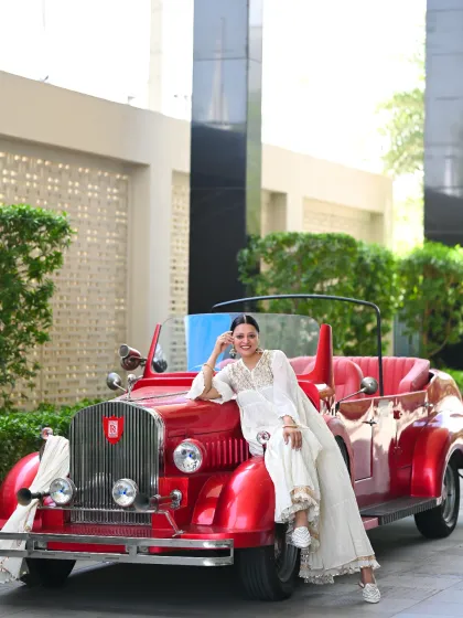 Vintage vibes. Posing with a classic red car in a beautiful all-white embroidered sharara set. This kind of thematic shoot is about creating a mood and transporting the viewer to another era.