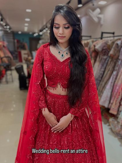 A full look at this fiery red lehenga with cape-style sleeves. It's a modern, powerful, and glamorous outfit available for you to rent and rock.