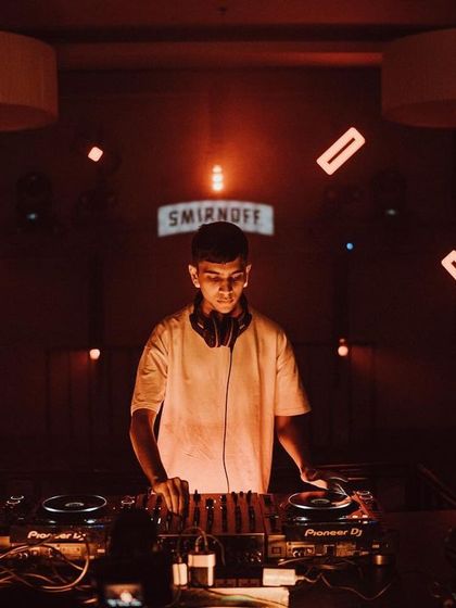 A DJ stands alone at the console, surrounded by a custom lighting rig. This shot highlights the scale and professionalism of our event productions.